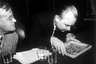 Former KGB officer Nikolai Khokhlov appears as a witness before the Senate Internal Security Subcommittee. Image shows Khokhlov examining a collection of bullets which contain poison. May. 21, 1954. (AP Photo) 